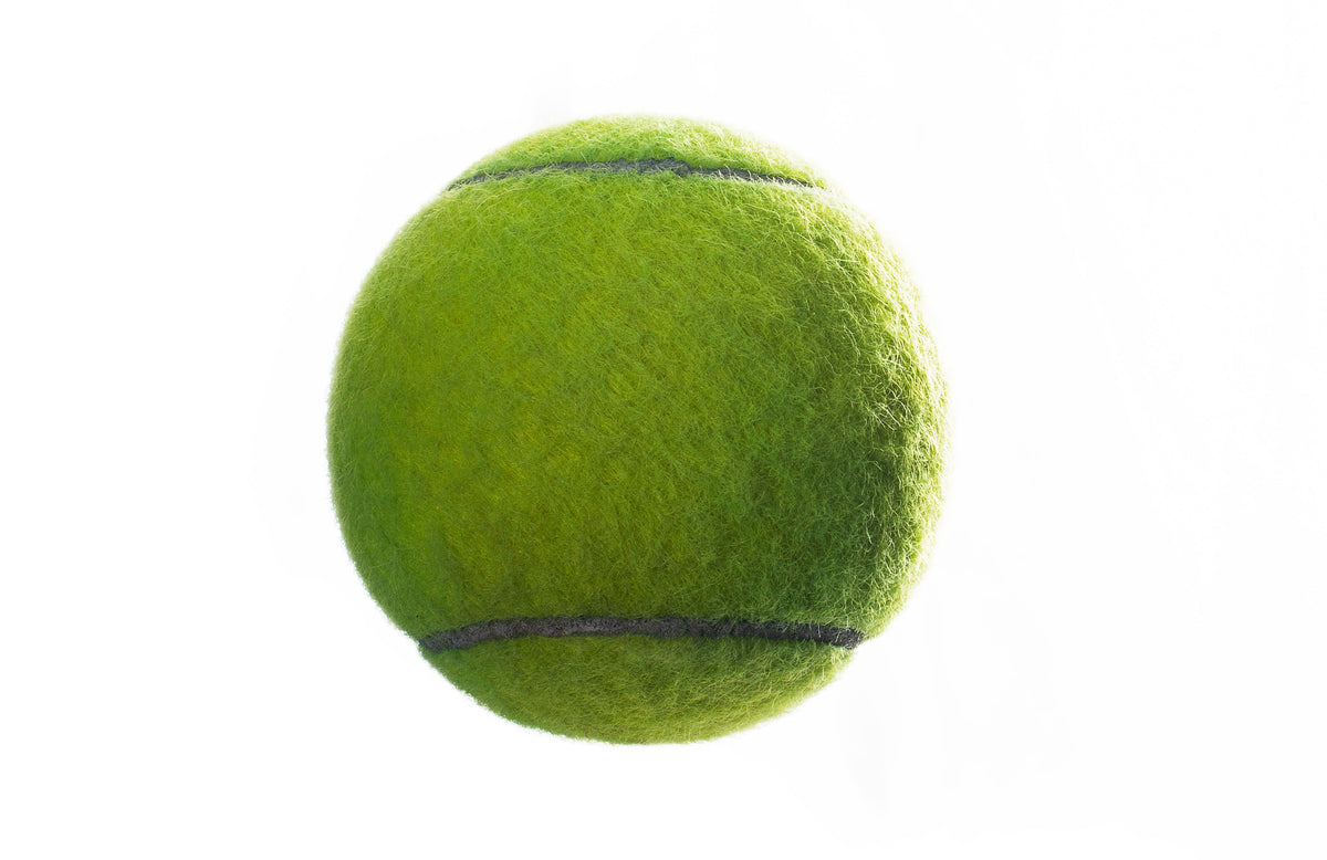 A tennis ball close up, showing the felt and seam